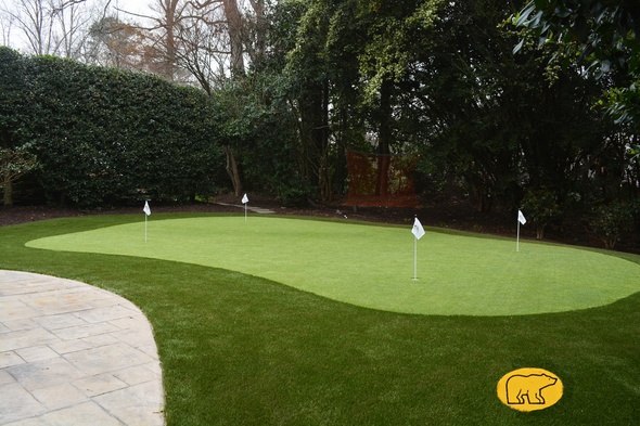 Edmonton Synthetic grass golf green with 4 holes and flags in a landscaped backyard