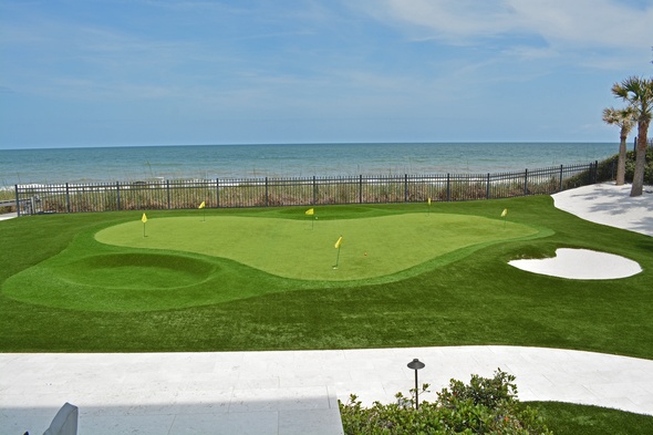 Edmonton Synthetic grass golf green by the sea with yellow flags and a sand bunker