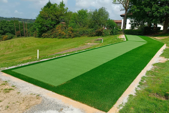 Edmonton Outdoor tee line consisting of one continuous green synthetic grass strip surrounded by trees